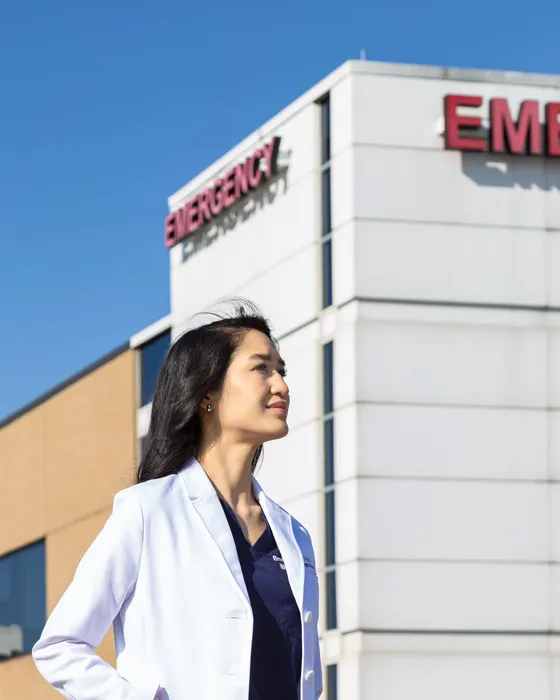 Amy Faith Ho, MD, in her white coat outside the emergency department